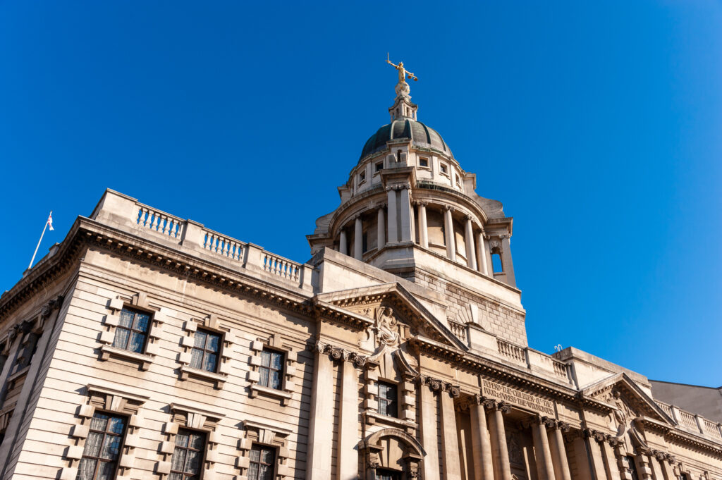 Exterior of the Old Bailey court building under a clear blue sky