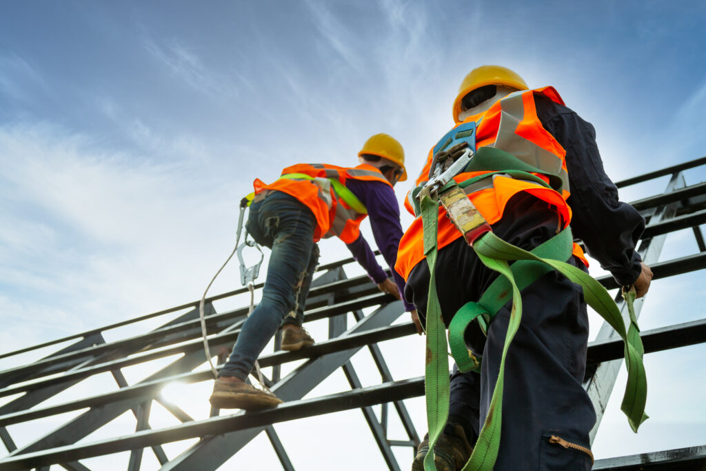 Workers with safety harnesses climbing a structure, representing working at height training