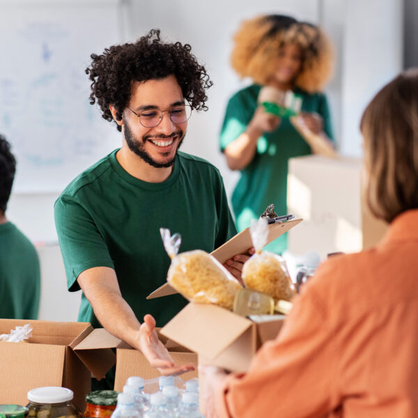 Volunteer handing a food parcel to a person in need.