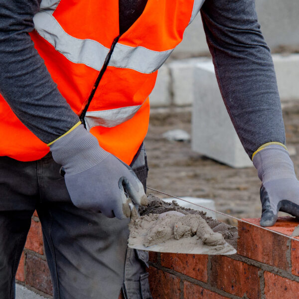 Bricklayer applying mortar to a brick wall